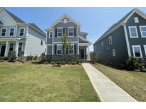 Charming two-story home featuring a stone facade and beautifully landscaped front yard at 1577 Goldfinch Perch Ln, Knightdale, NC 27545