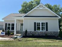 Charming single-story home with stone accents, a covered porch, manicured lawn and craftsman details at 202 S Pearl St, Princeton, NC 27569