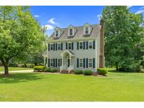 Charming two-story home with blue shutters and a well-manicured lawn at 209 Bradley Dr, Benson, NC 27504