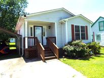 Charming single-story home with light siding, quaint front porch, and well-maintained landscaping at 220 Howard St, Burlington, NC 27217