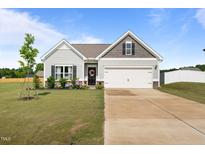 Charming single-Gathering home with a well-manicured lawn, two-car garage, and lovely front garden at 41 Liam Dr, Broadway, NC 27505