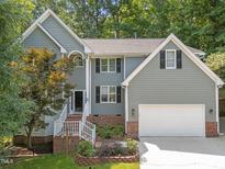 Charming two-story home features a two-car garage, manicured landscaping, and inviting entryway with brick accents at 6008 Chittim Ct, Raleigh, NC 27616