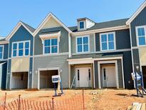 Modern townhome exterior featuring varied siding colors, large windows, and attached garages, offering contemporary living at 99 Ripple Way # 211, Clayton, NC 27520