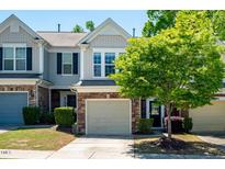 Charming townhome featuring a stone facade, attached garage, and manicured landscaping at 1116 Kingston Grove Drive Dr, Cary, NC 27519
