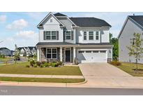 Charming two-story home featuring stone accents, a two-car garage, manicured lawn, and beautifully landscaped front yard at 121 Canyon Gap Way, Raleigh, NC 27610