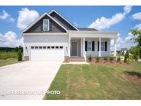Charming home with a two-car garage, covered porch, and well-manicured lawn at 214 Pretty Run Branch Ln, Wendell, NC 27591