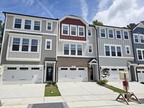 View of new construction townhomes featuring attached garages and neutral toned exteriors at 2203 Lambert Rd # 67, Cary, NC 27519