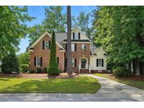 Charming two-story brick home with a manicured lawn, mature trees, and a welcoming front entrance at 3020 Woods Walk Way, Rocky Mount, NC 27804