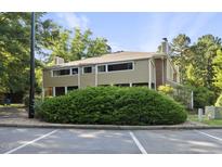 Tan two-story condo with green shrubs and a parking lot at 3427 Mill Run, Raleigh, NC 27612