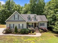 Charming home with dormer windows, stone accents, and well-manicured landscaping at 45 Chaucer W Ct, Zebulon, NC 27597