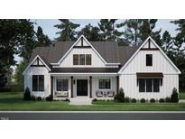 Charming craftsman-style home showcasing a symmetrical façade, covered porch, and manicured lawn at 50 Heritage Trail, Zebulon, NC 27597