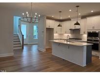 Beautiful kitchen features an island, stainless steel appliances, and ample cabinet space at 64 Rainfall Dr, Pittsboro, NC 27312