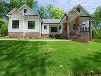 Charming home with brick accents, wood pillars and timber gable decoration on a manicured lawn and landscaping at 690 Oaks Lane Rd, Timberlake, NC 27583