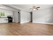 An open-concept living room and kitchen area with modern floors and updated appliances creates an inviting living space at 7924 Knightdale Blvd, Knightdale, NC 27545