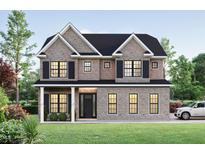 Elegant two-story home with a brick facade, black shutters, and a well-manicured lawn at 8011 Old Trail Dr, Durham, NC 27712