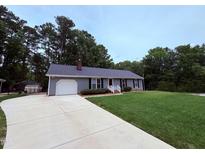Charming single-story home with an attached garage, driveway, and well-maintained lawn at 100 Honeysuckle Ln, Cary, NC 27513