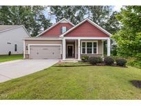 Charming exterior of a two-story home featuring a well-manicured lawn, covered entry, and attached two-car garage at 100 Pronghorn Deer Ct, Garner, NC 27529