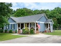 Charming home featuring blue siding, a welcoming front porch, and an American flag at 1008 Catsby Cir, Raleigh, NC 27603
