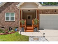 Charming brick home with covered front entrance, flower boxes, and a well-manicured lawn at 1051 Upland Reach, Sanford, NC 27332