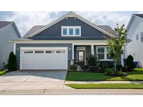 Beautiful home featuring a two-car garage, manicured lawn and professional landscaping at 1104 Briar Gate Dr, Holly Springs, NC 27540