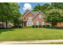 Charming two-story brick home featuring a lush green lawn and meticulously landscaped front yard at 1149 The Preserve Trl, Chapel Hill, NC 27517