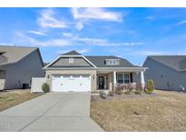 Charming brick home featuring a two-car garage and well-maintained front yard at 1206 Newton Dr Dr, Mebane, NC 27302