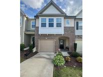 Charming townhome featuring a brick facade, one car garage, arched entryway and tidy landscaping at 136 Thornhill Dr, Burlington, NC 27215