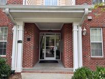 Covered doorway with white pillars and brick facade at Building 200 offers a welcoming entrance at 211 Providence Glen, Chapel Hill, NC 27514