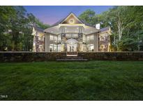 Stunning custom home featuring stone accents, a circular window, and manicured landscaping at 2207 Vintage Hill Dr, Durham, NC 27712