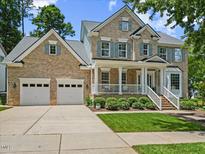Charming two-story brick home featuring a welcoming front porch and well-manicured lawn at 2419 Rogerson St, Raleigh, NC 27614