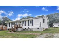 Charming one-story home with white siding, black shutters, and a wooden staircase leading to the front door at 2528 Barwick Dr, Durham, NC 27704