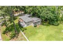 An aerial view of a charming house, showcasing its lush green lawn and a mature tree setting at 3012 Optimist Farm Rd, Apex, NC 27539