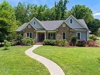 Charming single-story home with stone accents and a well-manicured lawn and paved walkway at 311 Rassie Crabtree Rd, Rougemont, NC 27572