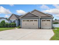 Spacious three-car garage with a concrete driveway and an attached blue-gray home at 45 Imperial Dr, Clayton, NC 27527