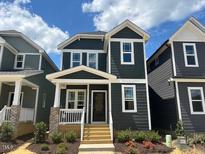 Charming two-story home with a dark exterior, well-manicured landscaping, and inviting front porch at 508 Yeowell Dr, Chapel Hill, NC 27514