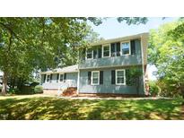 Charming two-story home with black shutters and brick accents, nestled under lush green trees at 8201 Blue Heron Way, Raleigh, NC 27615