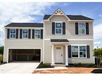 Charming two-story home with a modern design, open garage, and neutral siding at 102 Winterberry Dr, Sanford, NC 27330
