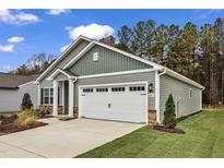Charming home featuring gray siding, a well-manicured lawn, and a two-car garage at 104 Old Arcadia Ln, Youngsville, NC 27596