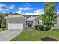Charming single-story home with a stone facade, two-car garage, and well-maintained lawn at 119 Blossom Creek Dr, Garner, NC 27529