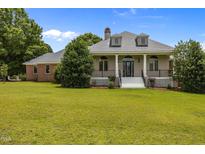 Charming home featuring a well-manicured front yard, classic architectural design and inviting entryway at 1672 Wheeler Dr, Angier, NC 27501