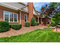 Charming brick home with well-manicured lawn, lush landscaping, and inviting curb appeal at 1831 Middlebrook Dr, Raleigh, NC 27615