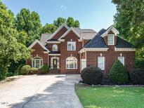 Beautiful two story brick home with manicured lawn, mature landscaping, and an extended driveway at 230 Paula Dr, Angier, NC 27501