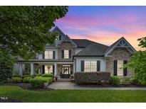 Beautiful two-story home featuring stone accents, a landscaped yard, and a welcoming front porch at 237 Bendemeer Ln, Rolesville, NC 27571