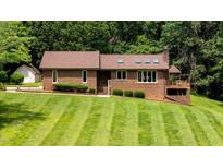 Charming brick home with a manicured lawn and mature trees providing a serene and private setting at 2523 Lovette Ln, Graham, NC 27253