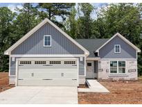 Charming single-story home with a two-car garage, grey siding, and manicured landscaping at 307 Rothbury Ct, Sanford, NC 27330