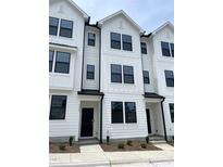 Modern townhome with a white exterior, black window frames, and a well-manicured front yard at 3103 White Blossom Ct, Raleigh, NC 27610