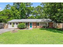Charming ranch home with well-manicured lawn, brick accents, teal front door, and lush landscaping at 3216 Idlewood Village Dr, Raleigh, NC 27610