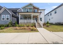 Charming two-story home with a welcoming front porch and beautifully landscaped front yard at 34 Millennium Dr, Pittsboro, NC 27312