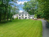 Stunning traditional white house with lush green lawn and mature trees at 3540 Rugby Rd, Durham, NC 27707