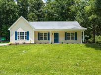 Charming single-story home with blue shutters and a well-manicured lawn at 381 Gray Ghost Ln, Benson, NC 27504